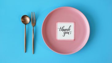 table setting meal preparation with thank you card on round plate t20 jRBP7X