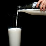 person pouring milk in highball glass 1435706